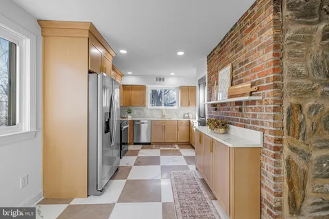 a kitchen with stainless steel appliances kitchen island granite countertop a refrigerator and a sink