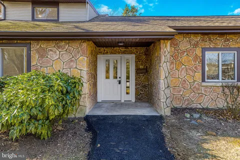 a front view of a house with a yard and trees