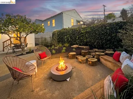 a view of a backyard with table and chairs potted plants and a building