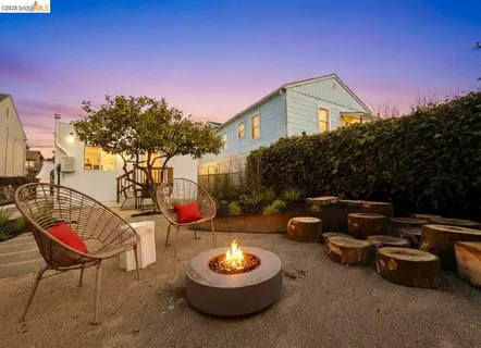 a backyard of a house with barbeque oven table and chairs