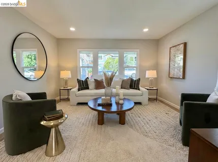 a living room with furniture a window and a potted plant