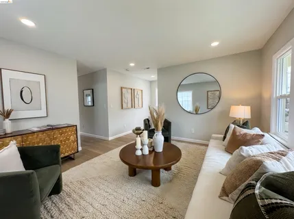 a living room with furniture a mirror and a fireplace