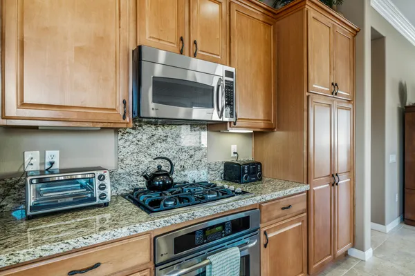 a kitchen with stainless steel appliances granite countertop a stove and a microwave
