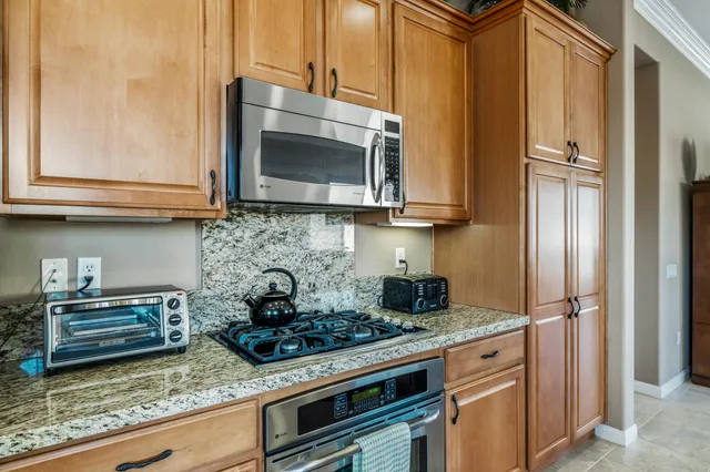 a kitchen with stainless steel appliances granite countertop a stove and a microwave