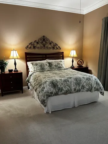 a bedroom with a bed and a lamp on desk