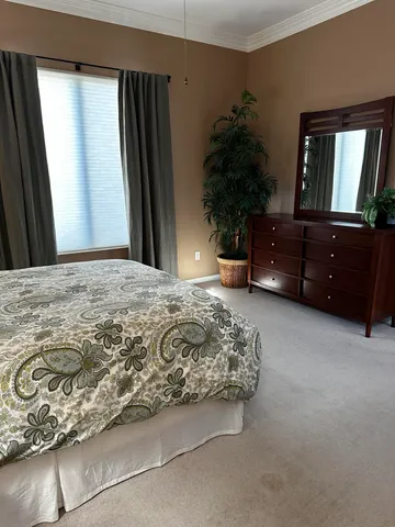 a bedroom with a bed dresser and a mirror