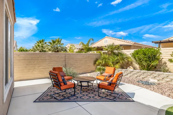 a patio with table and chairs and potted plants
