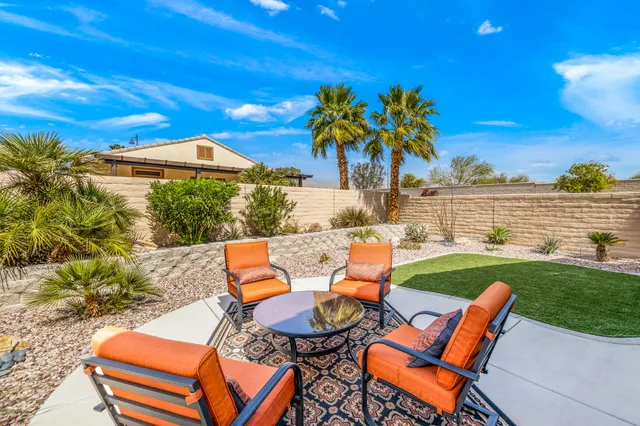 a view of a chairs and table in patio with a yard