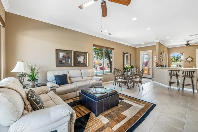 a living room with furniture potted plant and open kitchen view