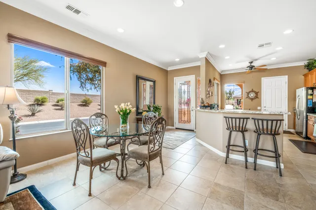 a dining room with furniture and large windows