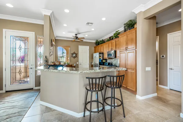 a kitchen with stainless steel appliances kitchen island granite countertop a refrigerator and cabinets