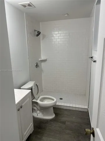 a white toilet sitting next to a bath tub