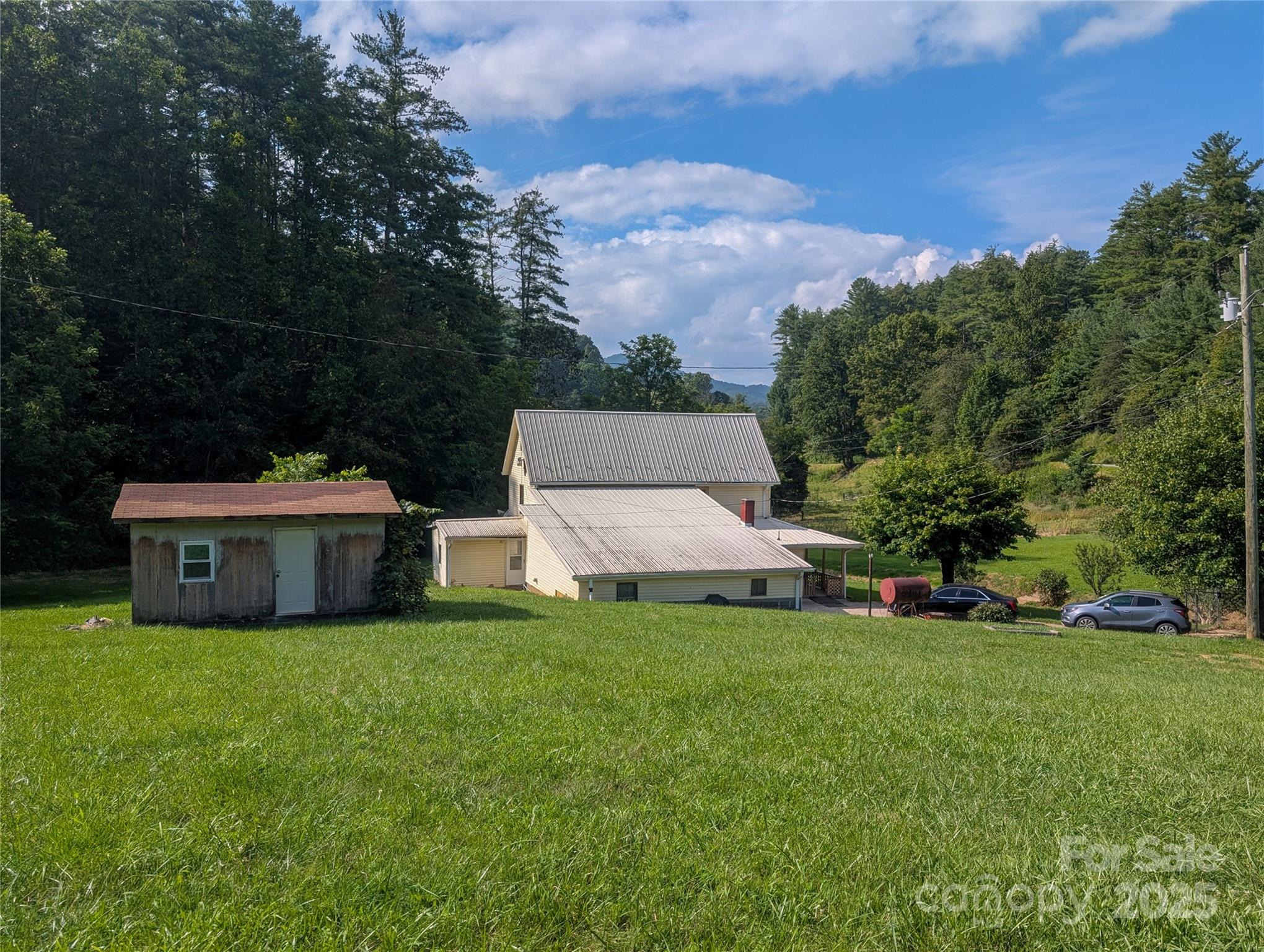 540 Pound Mill Branch Road Burnsville, NC 28714 - Photo 15 of 43 a view of a house with a big yard and large trees
