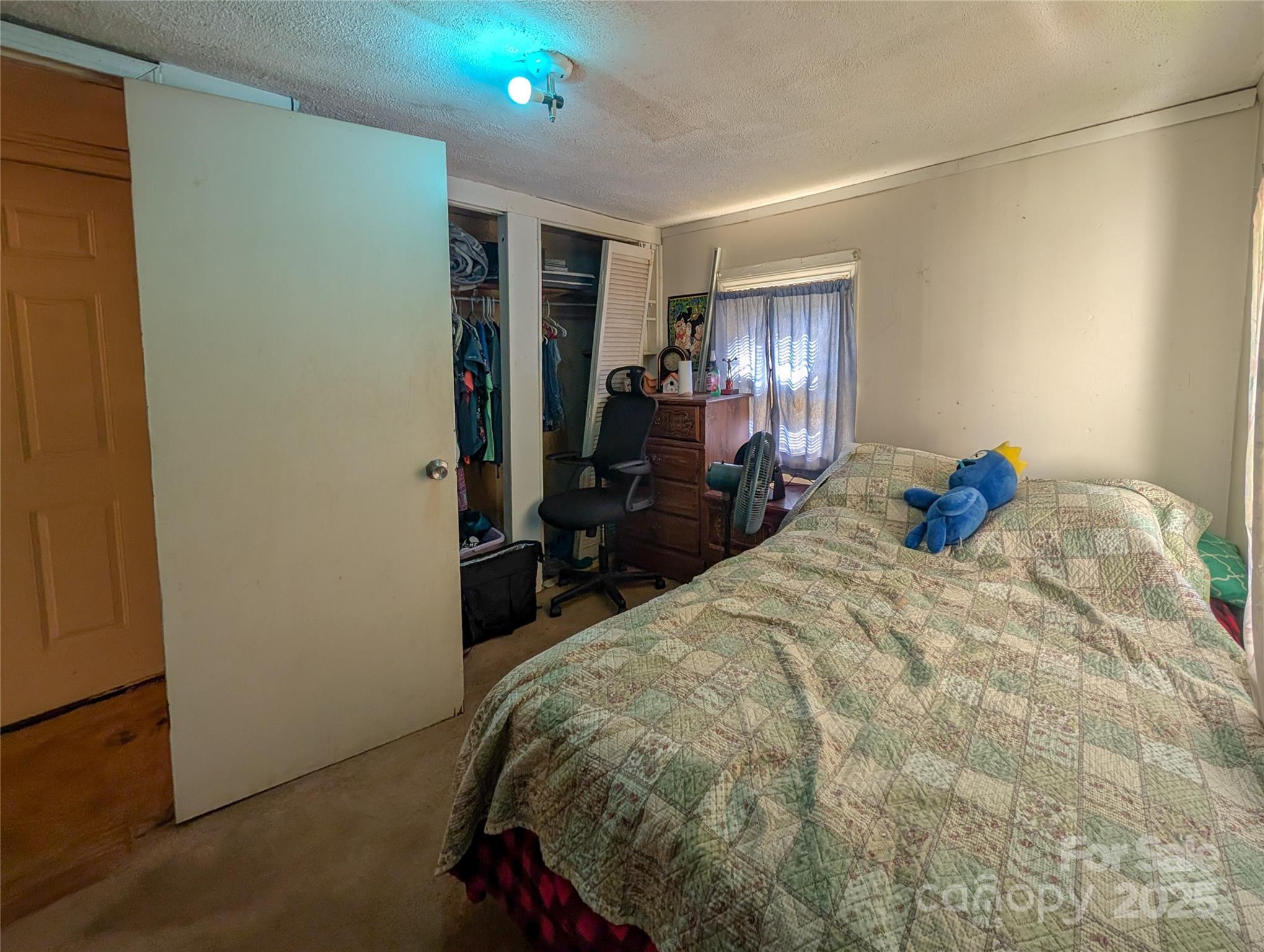 540 Pound Mill Branch Road Burnsville, NC 28714 - Photo 37 of 43 a bed sitting in a bedroom and chair