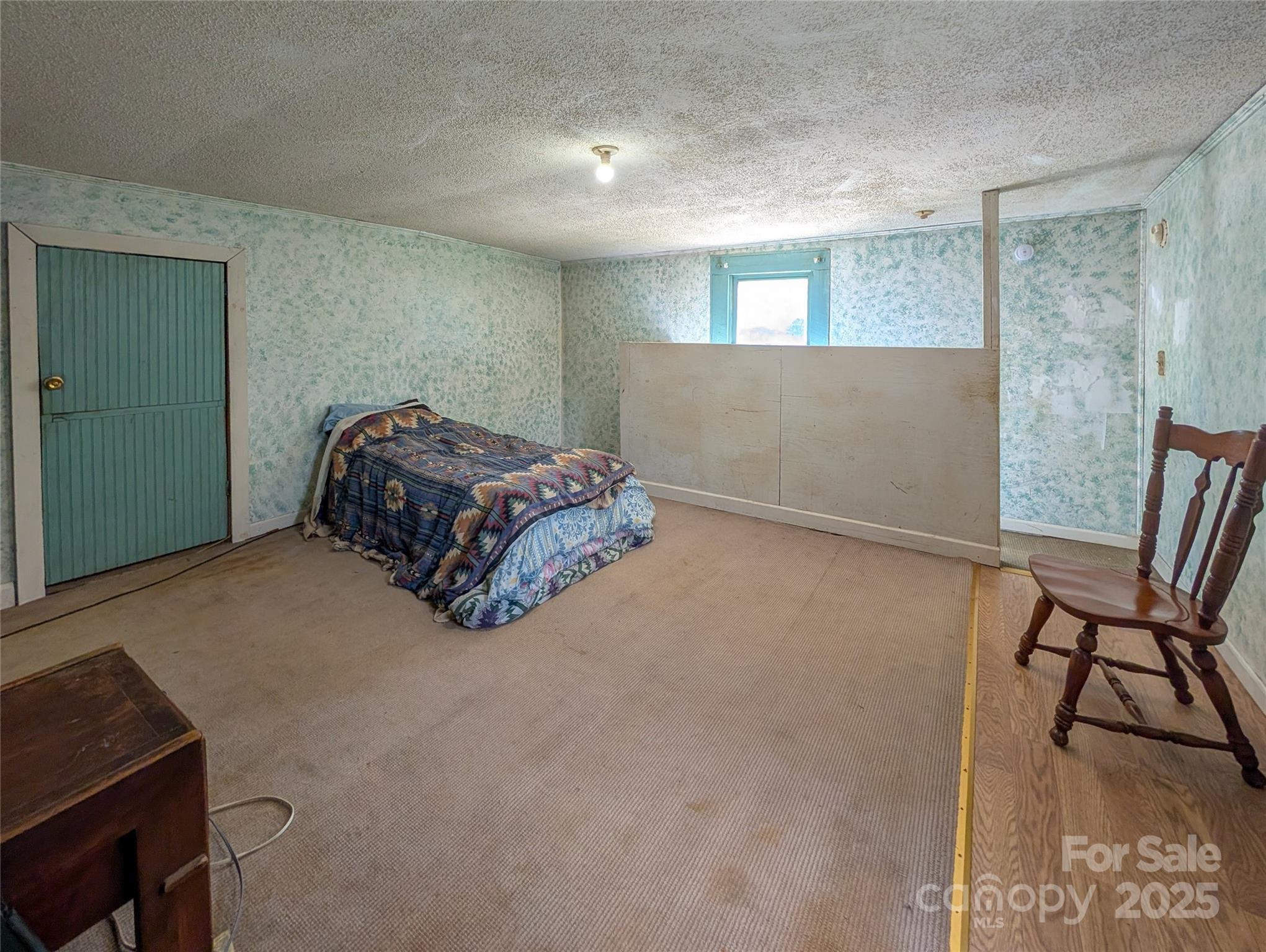 540 Pound Mill Branch Road Burnsville, NC 28714 - Photo 41 of 43 a bedroom with a bed and chair