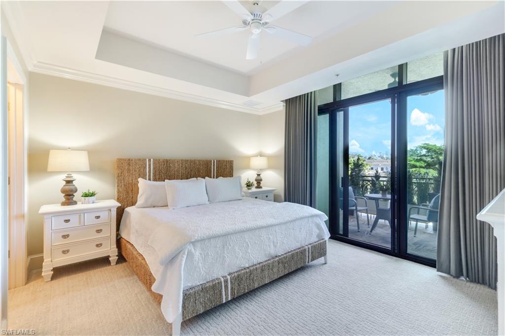 9115 Strada Place, Unit 5205 Naples, FL 34108 - Photo 12 of 36 a bedroom with a large bed and a chandelier fan