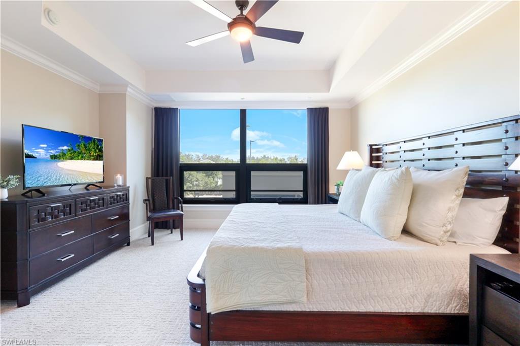 9115 Strada Place, Unit 5205 Naples, FL 34108 - Photo 17 of 36 a bedroom with a large bed and a flat tv screen on dresser