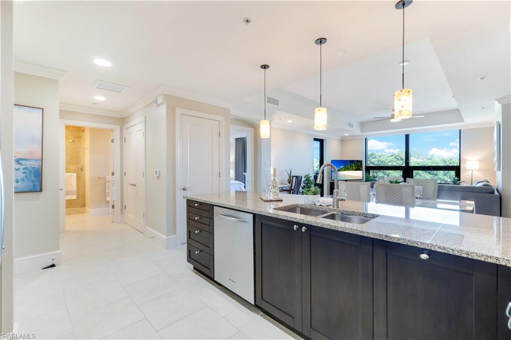 9115 Strada Place, Unit 5205 Naples, FL 34108 - Photo 36 of 36 a kitchen with stainless steel appliances kitchen island granite countertop a sink a counter top space and cabinets