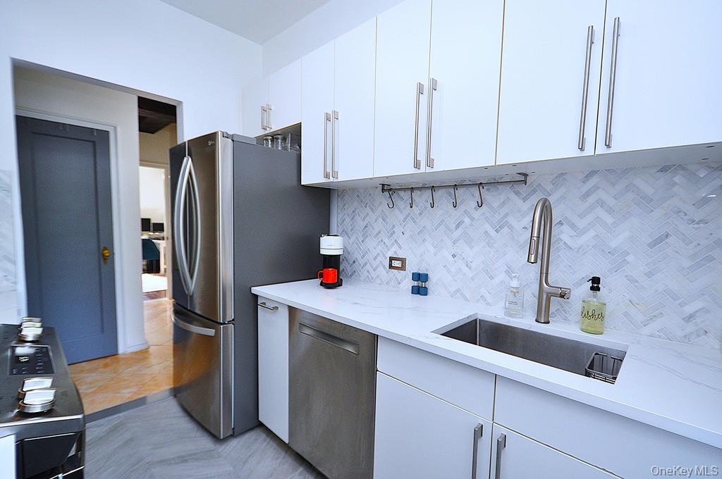 192 Garth Road, Unit TP Scarsdale, NY 10583 - Photo 13 of 43 The thoughtfully renovated kitchen is a chef’s delight, showcasing stainless steel appliances, custom white cabinetry, abundant quartz countertops, and generous workspace.