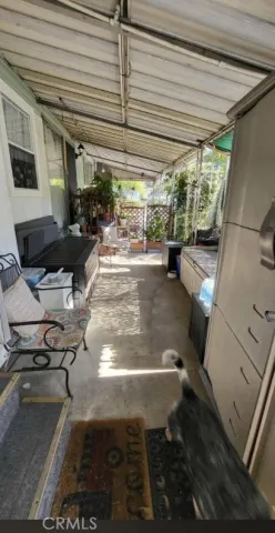 a living room with furniture a flat screen tv and a refrigerator