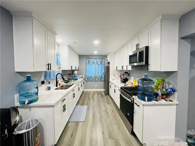 a kitchen with kitchen island granite countertop lots of counter top space a sink a stove and cabinets