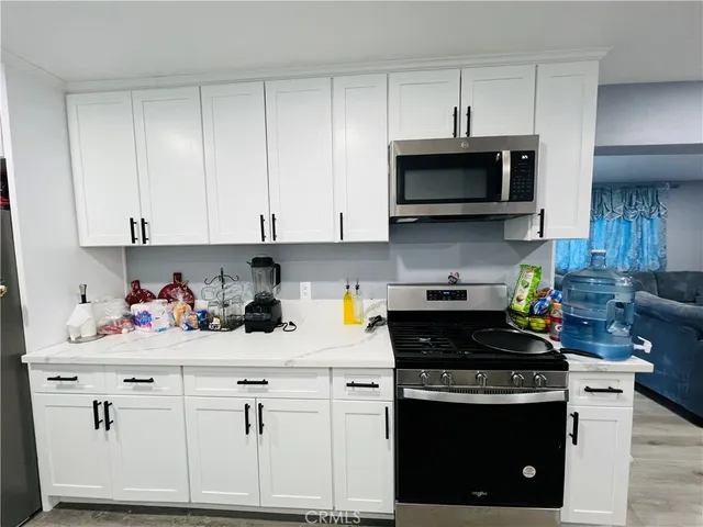 a kitchen with stainless steel appliances granite countertop a sink a stove a microwave and cabinets