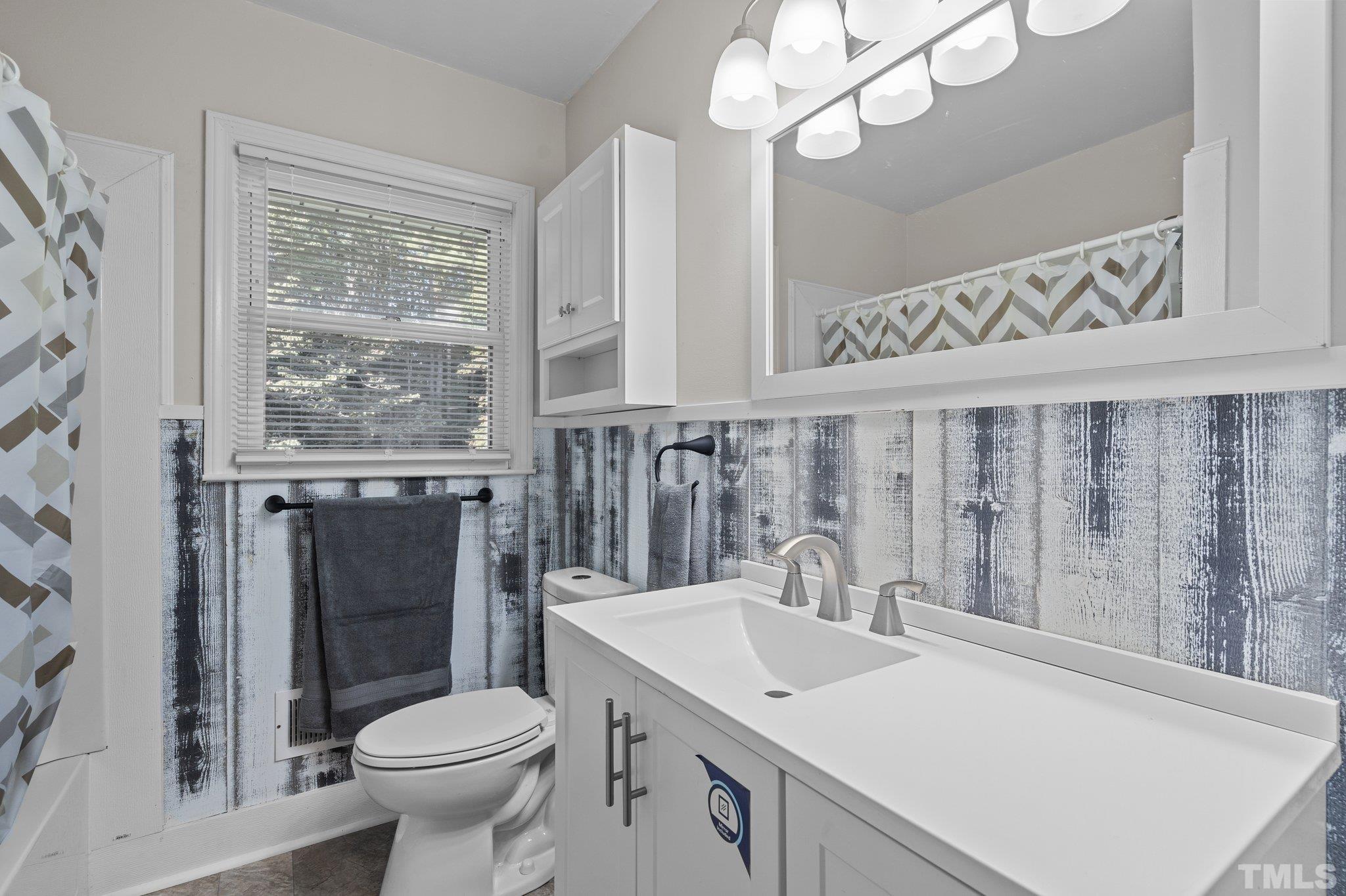 3645 Hicksboro Road Henderson, NC 27537 - Photo 26 of 37 a bathroom with a sink a toilet a mirror and shower