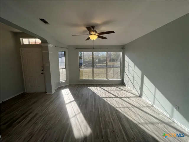 wooden floor in an empty room with a window