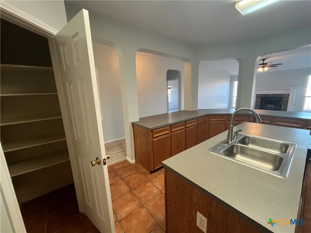 a view of a livingroom with a fireplace a ceiling fan and wooden floor
