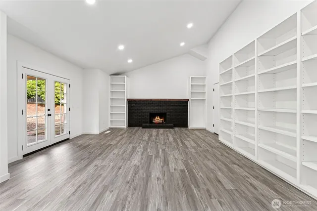 a view of an empty room with a fireplace and a window