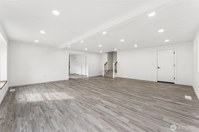 a view of an empty room with wooden floor
