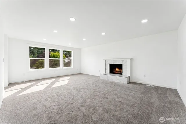 an empty room with a fireplace and window