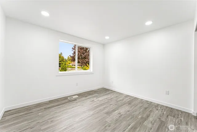an empty room with wooden floor and window