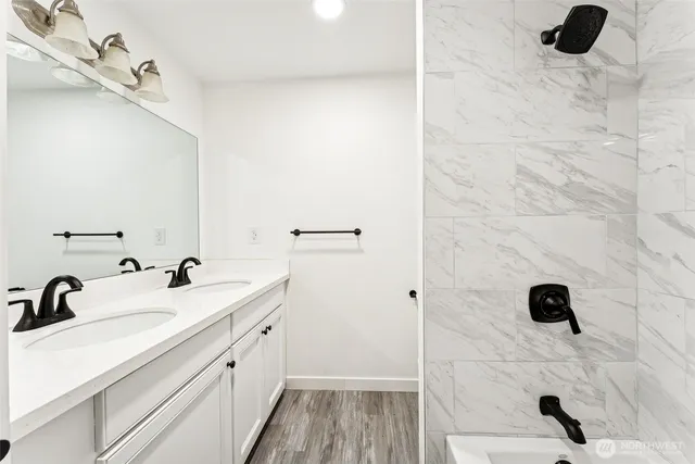 a bathroom with a double vanity sink a mirror and shower