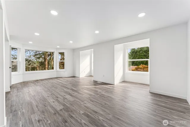 an empty room with wooden floor and window