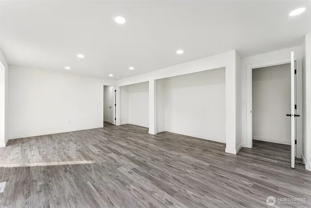 a view of empty room with wooden floor