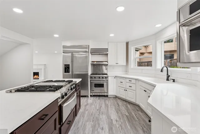 a kitchen with stainless steel appliances granite countertop a stove sink and cabinets