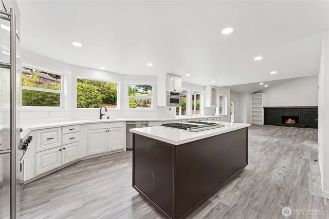 a kitchen with kitchen island granite countertop a stove and a sink