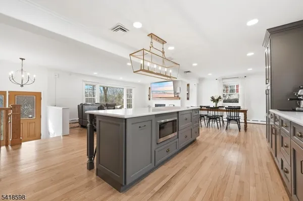 a kitchen with stove a sink dishwasher a dining table and chairs with wooden floor