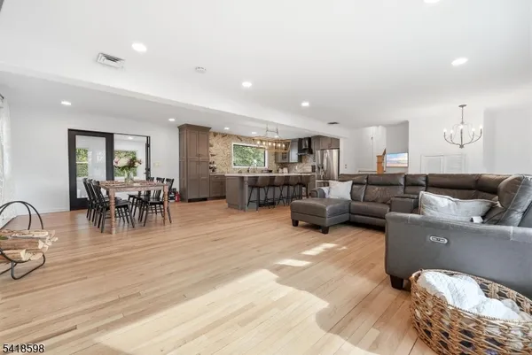 a living room with furniture and a view of kitchen