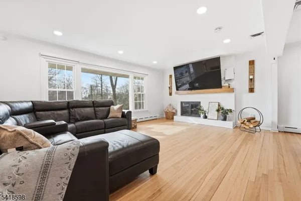 a living room with furniture a flat screen tv and a fireplace