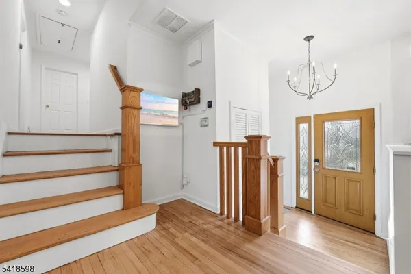 a view of empty room with wooden floor and windows