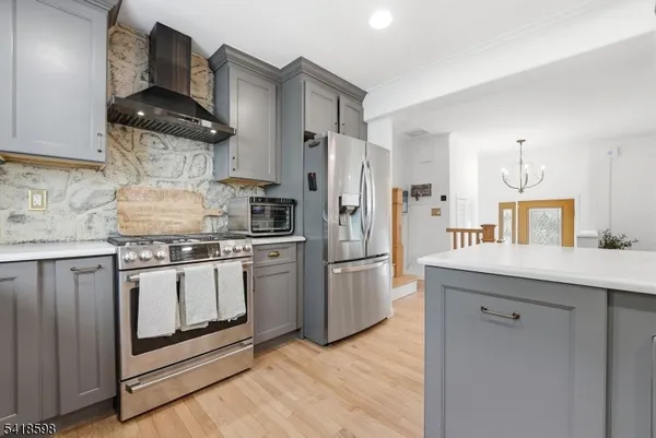 a kitchen with stainless steel appliances granite countertop a refrigerator a stove and a sink