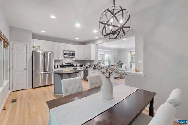 a dining room with furniture a chandelier and wooden floor