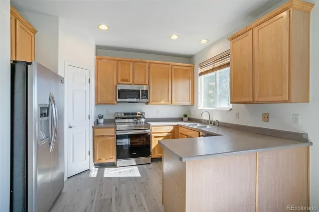a kitchen with stainless steel appliances granite countertop a refrigerator stove top oven and sink