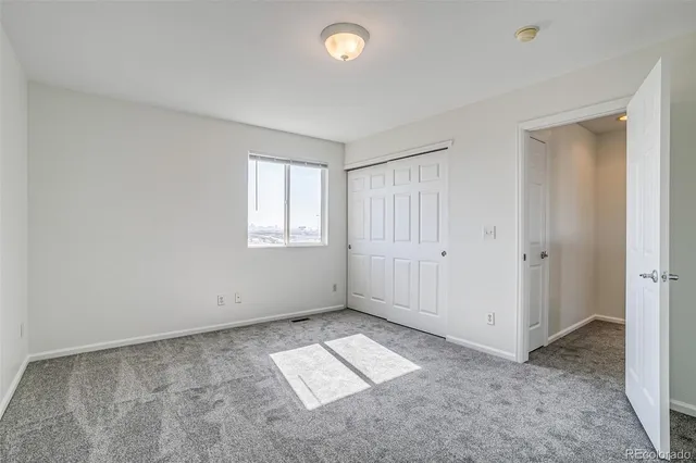 an empty room with windows and closet