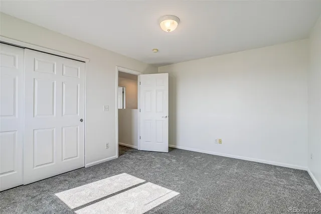 an empty room with windows and closet