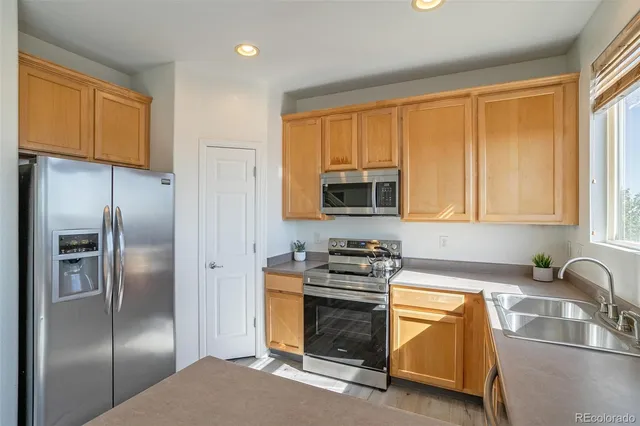 a kitchen with stainless steel appliances granite countertop a refrigerator stove and sink