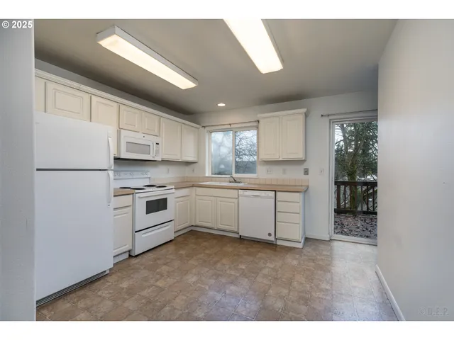 a kitchen with white cabinets and white appliances