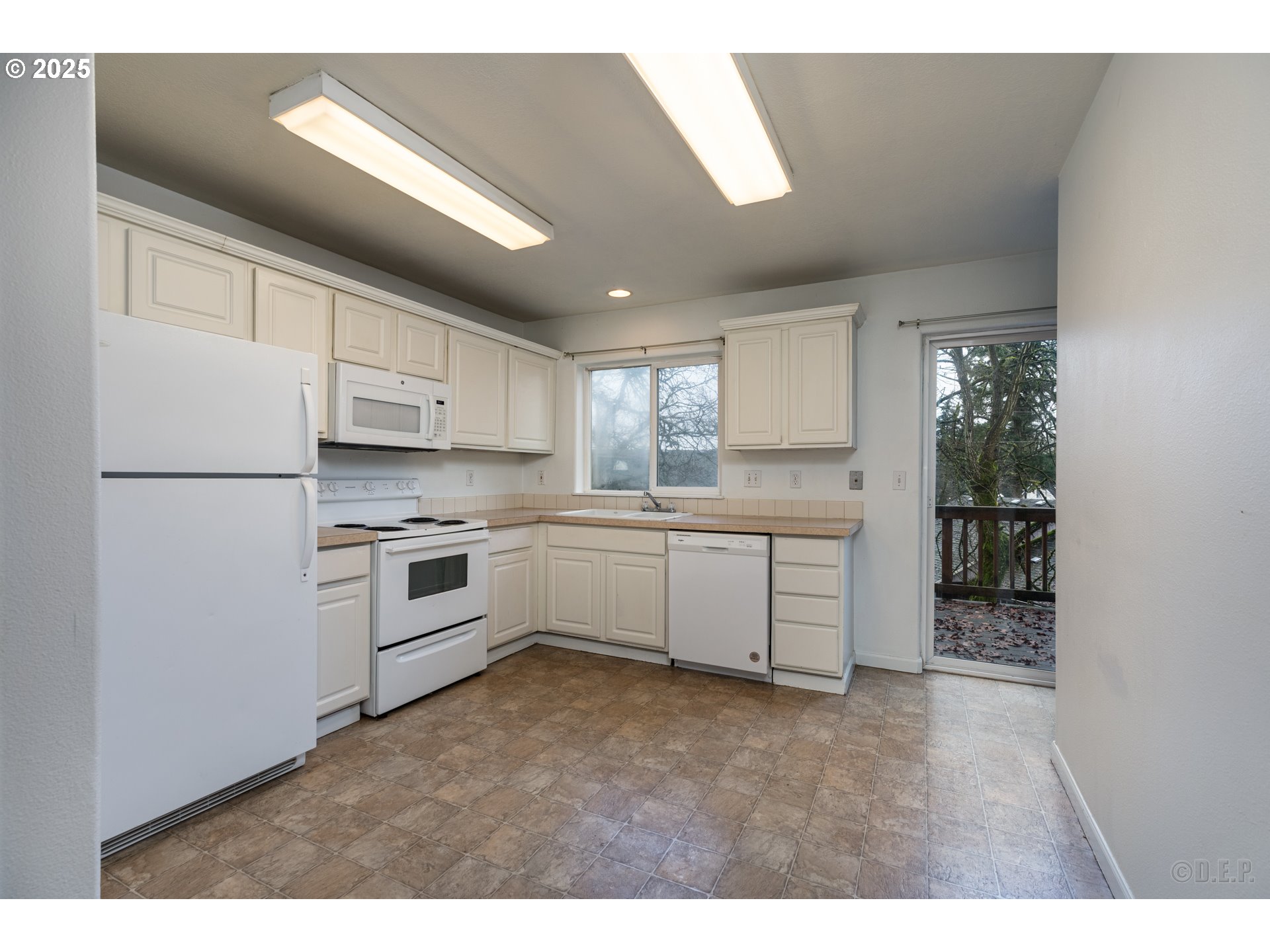 744 Oregon Street St. Helens, OR 97051 - Photo 5 of 11 a kitchen with white cabinets and white appliances